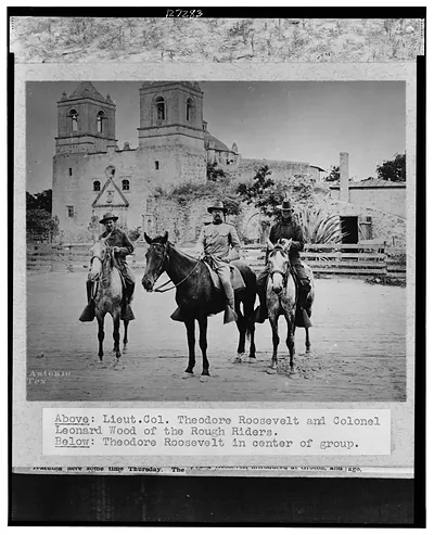 [Theodore Roosevelt posed on horseback, in uniform, between two other men also on horseback, in front of church San Antonio, Texas, during the Spanish-American War]
