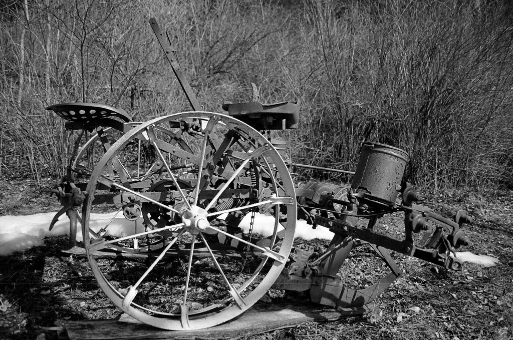 Rusted antique farm implement with large iron wheels — historic image
