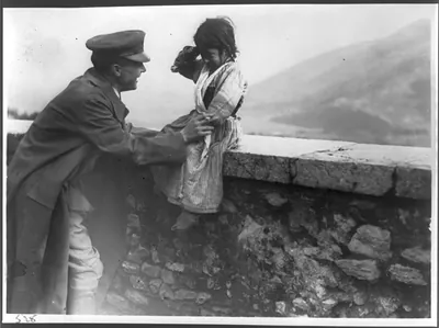 [War orphan from the Appenines seated on wall with ARC soldier, Pontine Marshes, Italy]