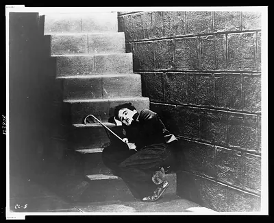 [Charlie Chaplin, full-length portrait, sleeping on stairs in a scene from the movie City Lights"]"