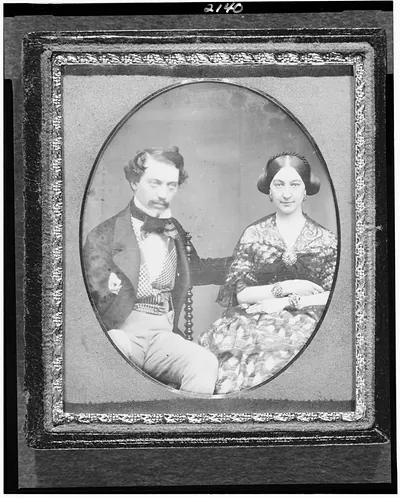 [Hickson W. and Mary Elizabeth Field, three-quarter length portrait of a man seated in a chair beside a woman with elaborate jewelry]