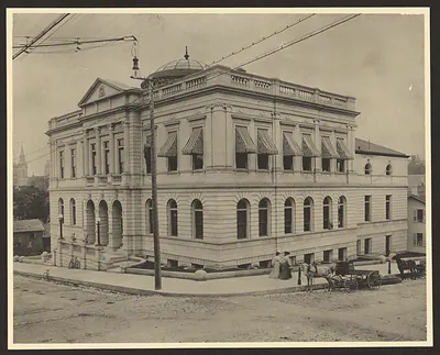 Stone civic building with dome and horse-drawn carriage
