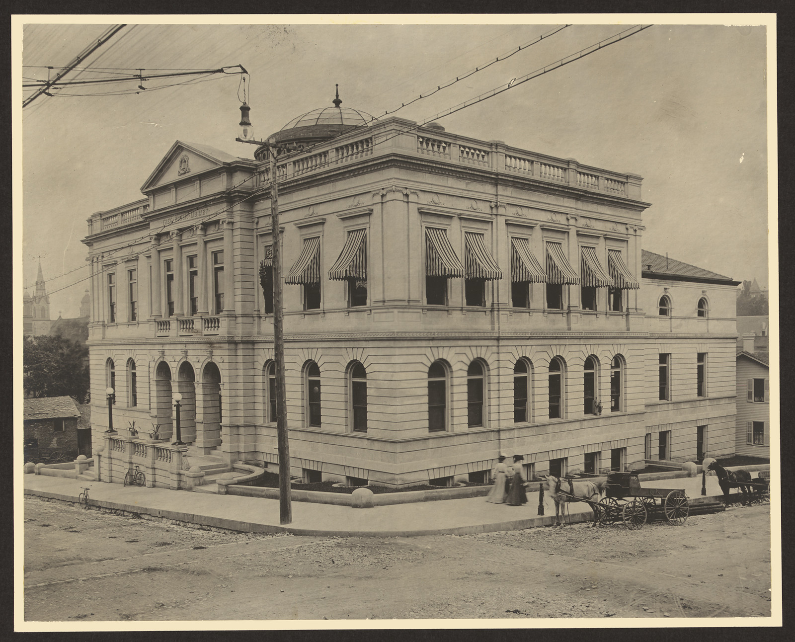 Stone civic building with dome and horse-drawn carriage — historic image