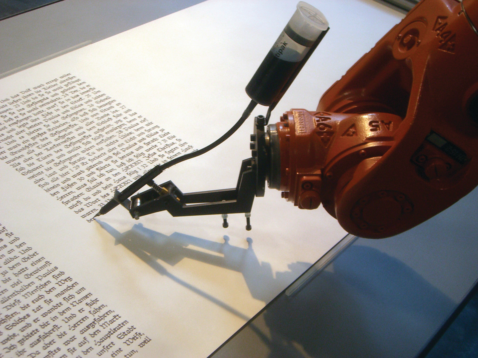 Industrial robot arm writing text on paper — historic image