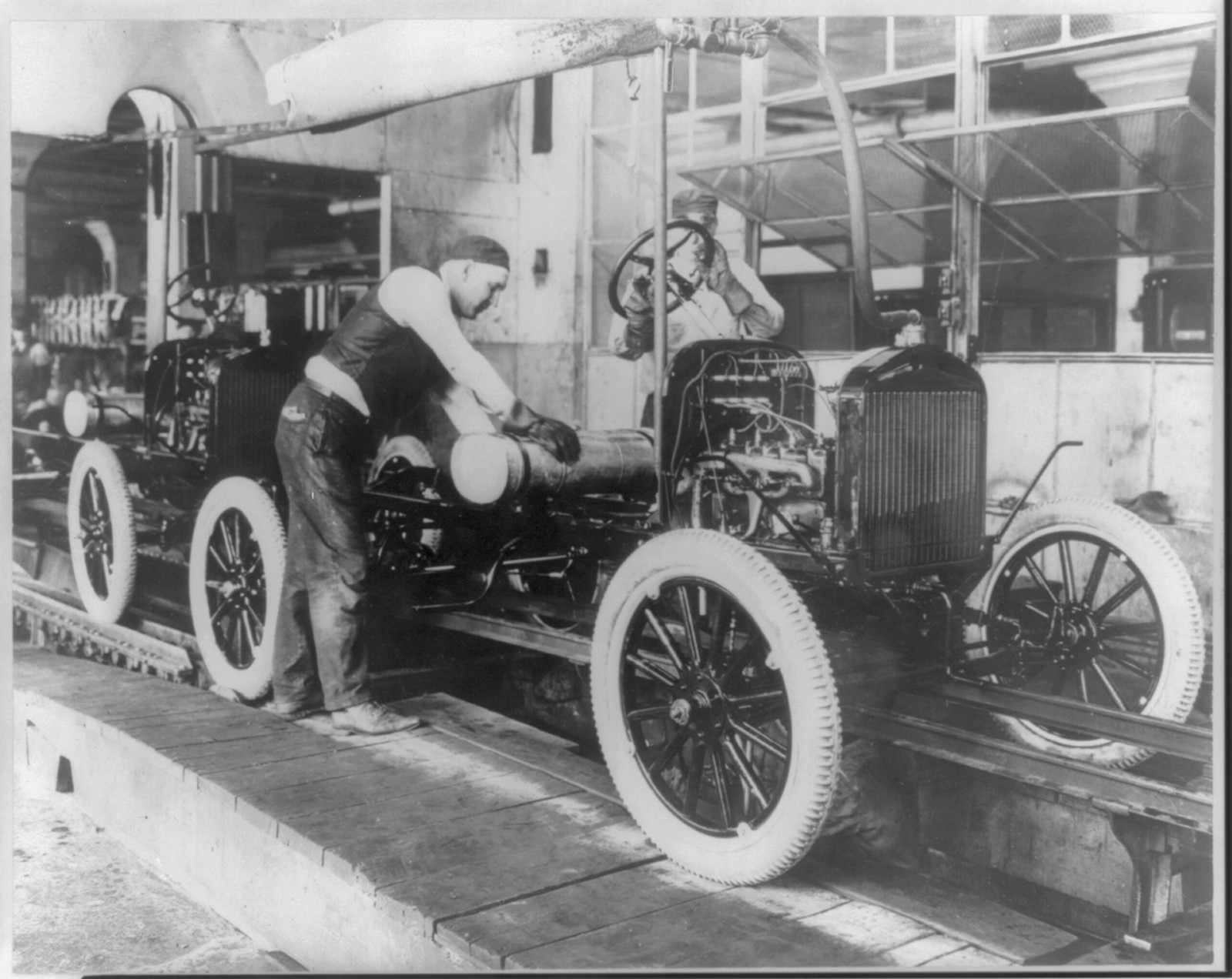 [Workers on Ford Motor Co. assembly line] — historic photograph
