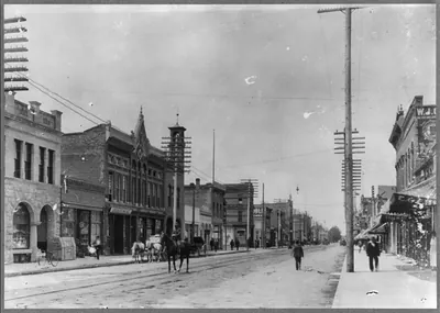 [Street scene with horses, undertaking sign on building bearing Masonic insignia, Boise, Idaho]