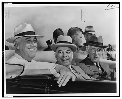 [President Franklin D. Roosevelt, Prime Minister W.L. Mackenzie King, and Henry L. Stimson ride in a car during memorial services near Lisbon, N.Y., in memory of the dead of the 28th Division, Pennsylvania National Guard, where they agreed to create a permanent joint Canadian-United States board for defense of the Western hemisphere]