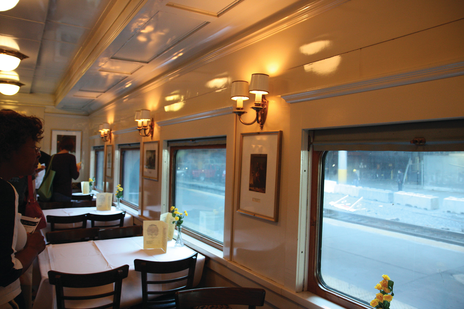 Dining car interior with set tables and wall sconces — historic image