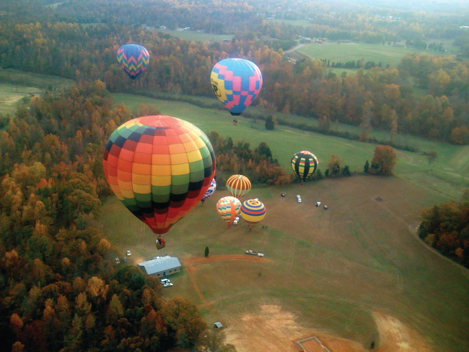 Hot air balloons over autumn countryside seen from above — historic image