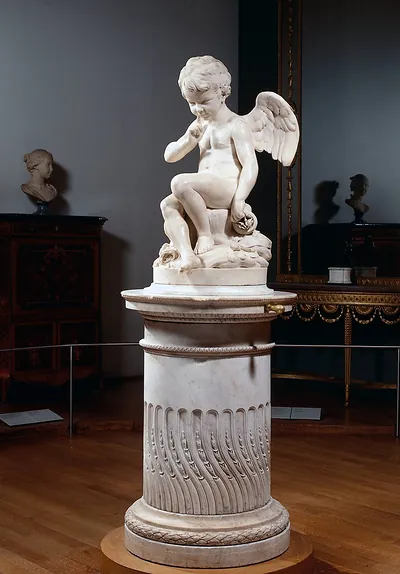 Marble cupid statue with finger to lips on pedestal