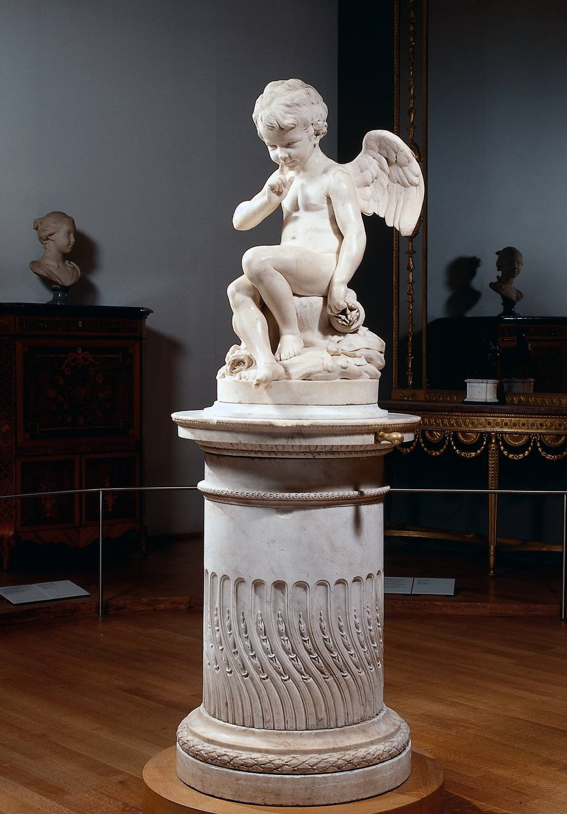 Marble cupid statue with finger to lips on pedestal — historic image