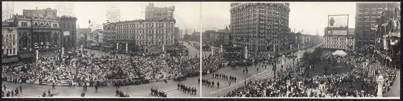 Panoramic photograph of a crowded city parade, Detroit-style street — historic photograph