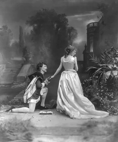Man kneeling to a woman in a gown before a painted garden