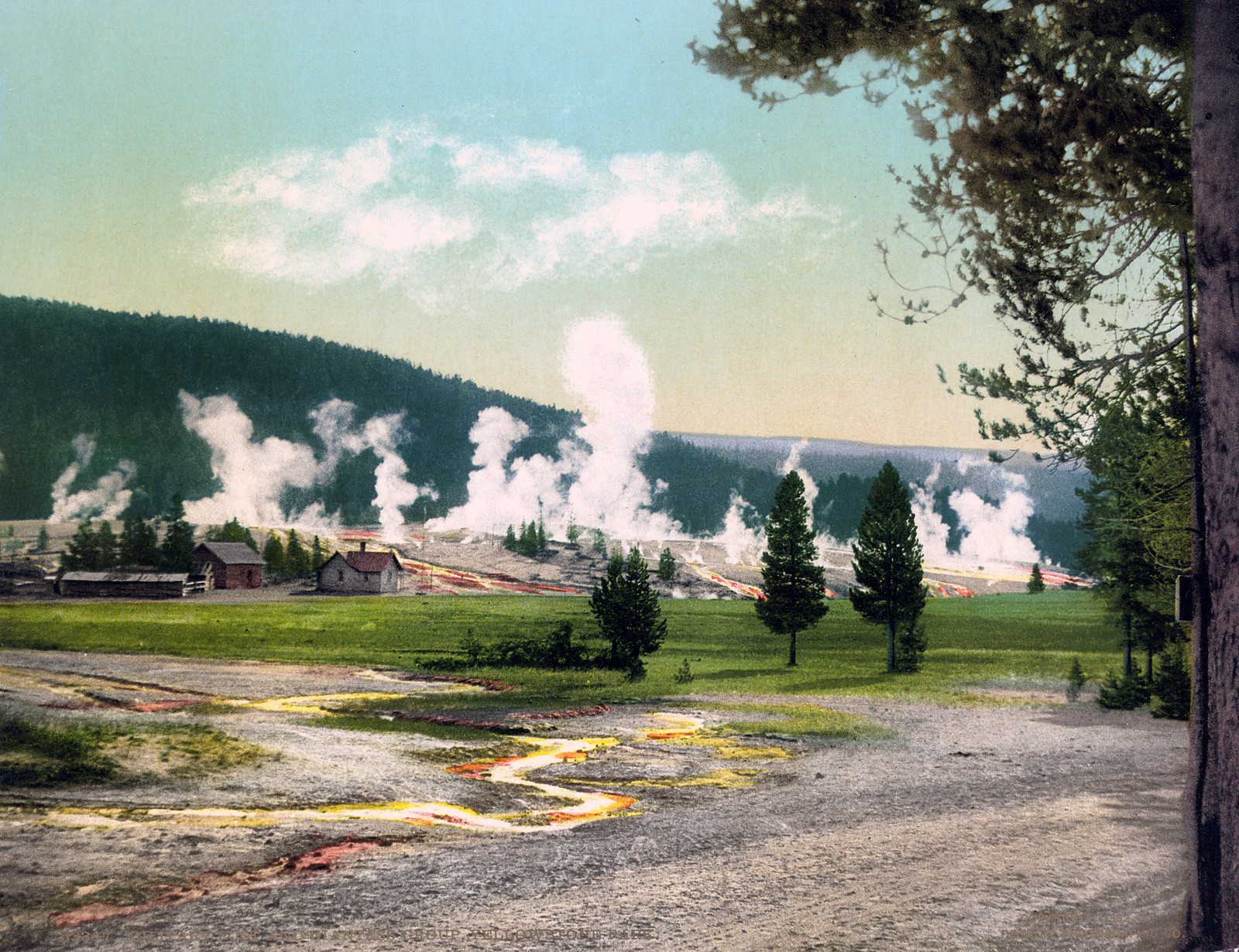 Geysers steaming over Yellowstone basin with cabins and pines — historic image