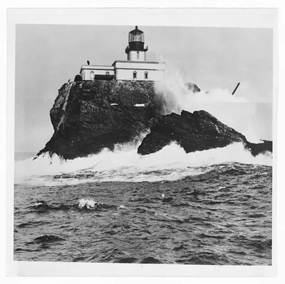 Lighthouse on a rocky islet in heavy surf