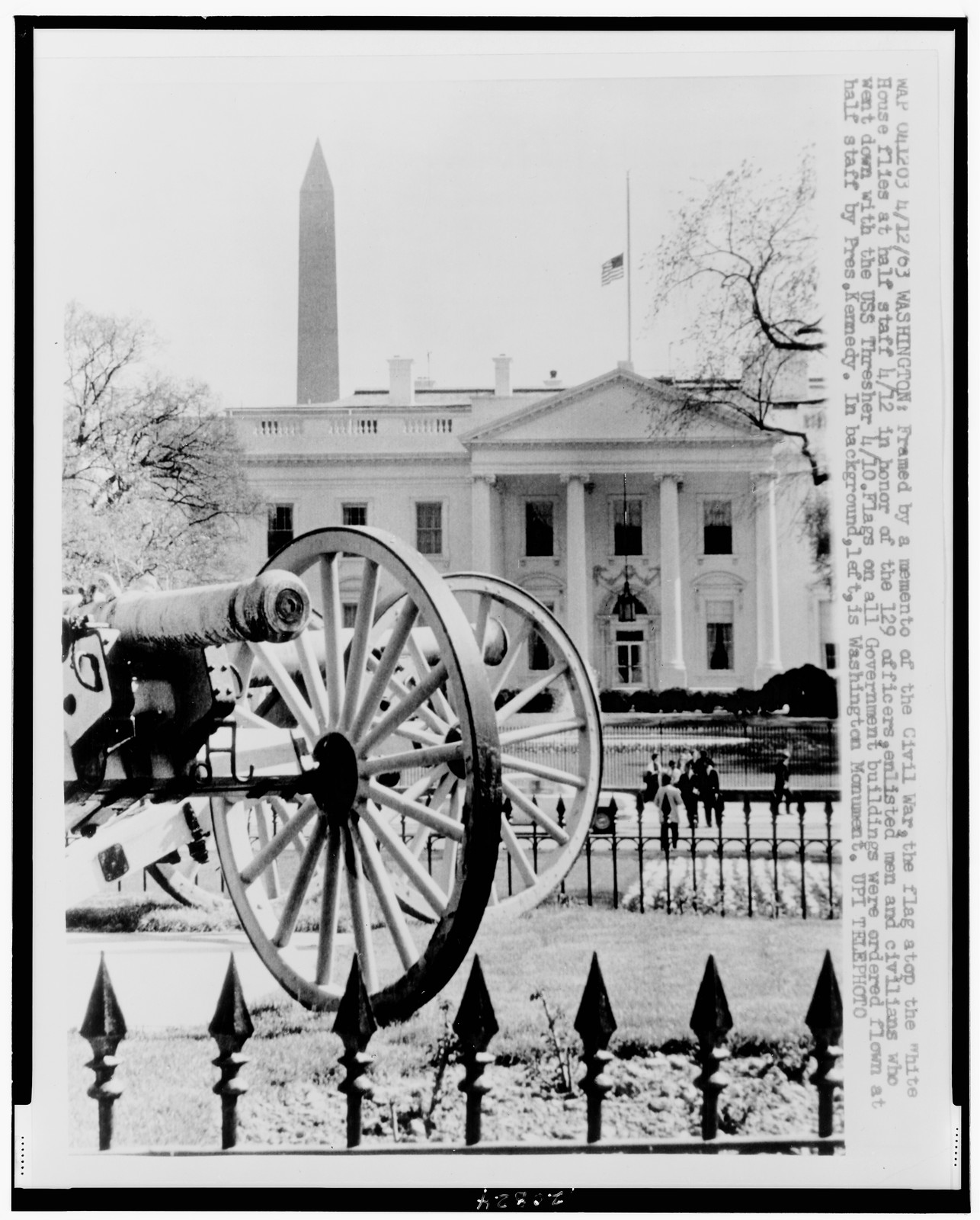 [Front facade of White House with flag at half-mast in honor of those who lost their lives on the USS Thresher; Civil War cannons in foreground] — historic photograph