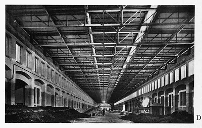 Interior of a long covered hall with steel trusses and arches