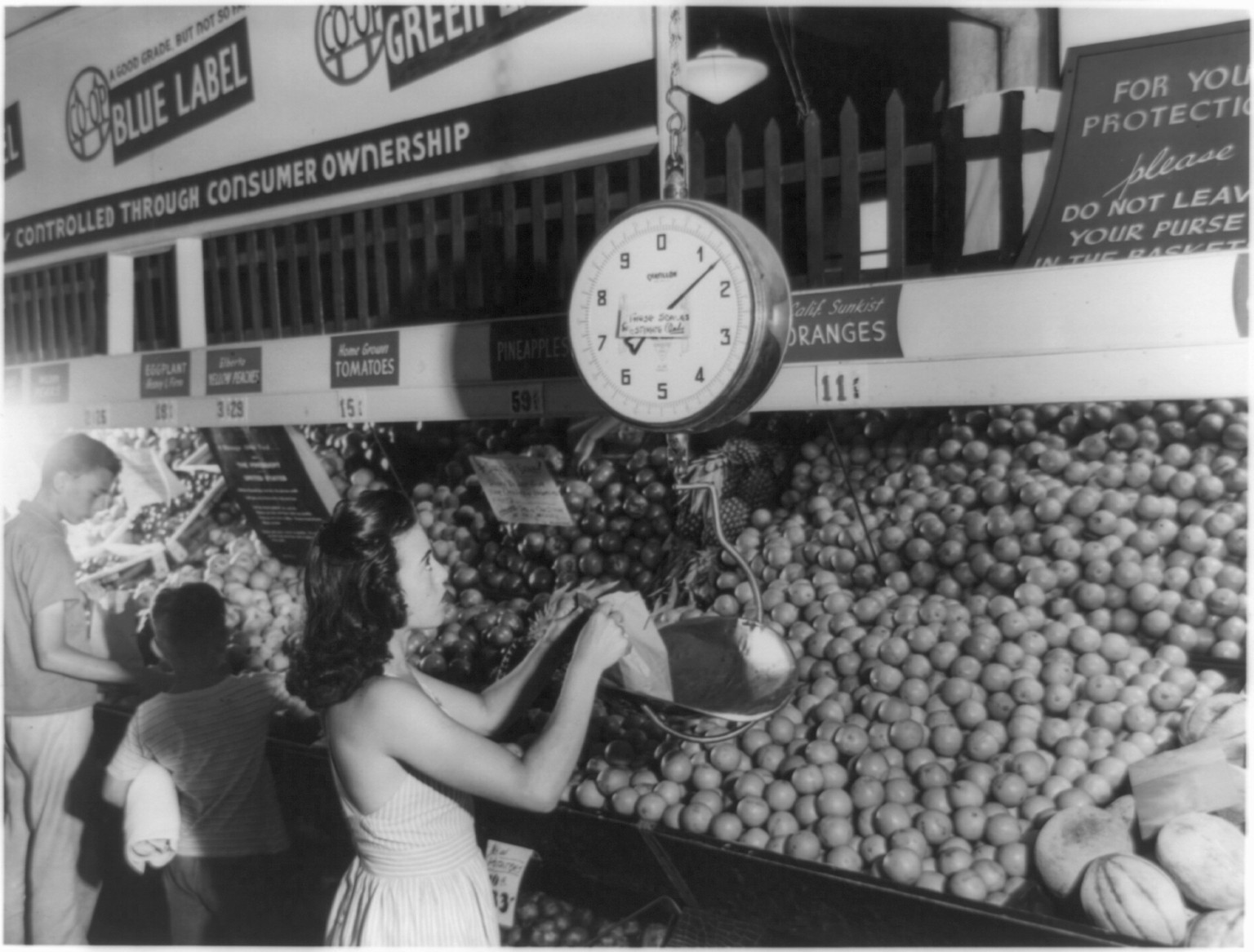[Greenbelt, Md.: woman weighing produce in grocery store], 1946 July. — historic photograph
