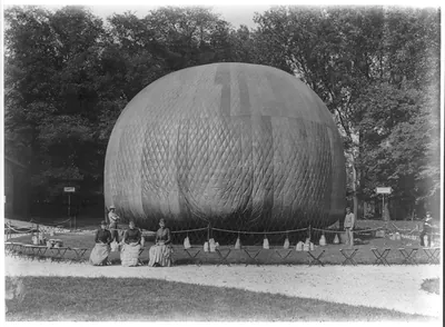 Balloon being inflated with seated women and standing men