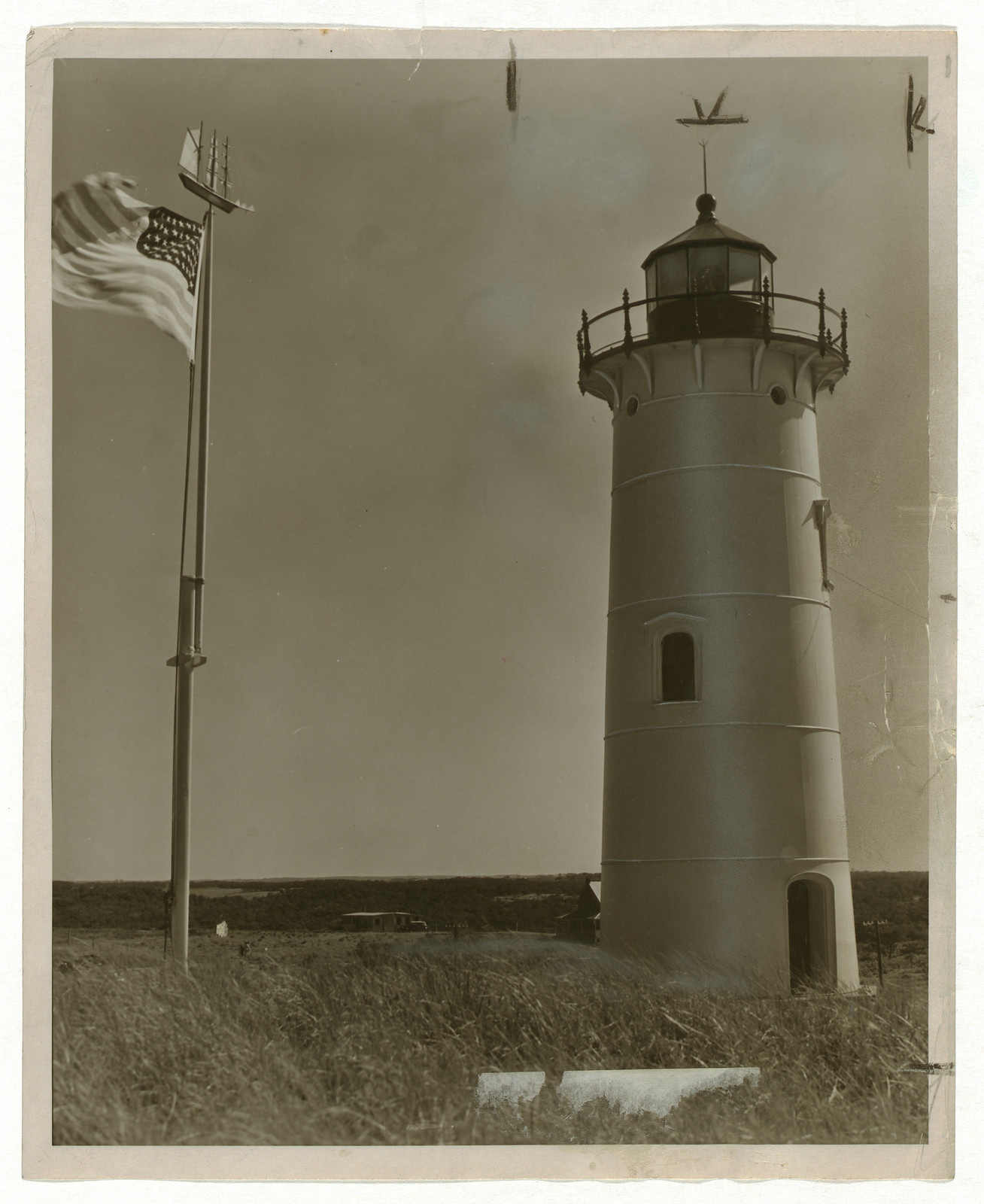 Lighthouse with American flag and weathervane, sepia photograph — historic photograph