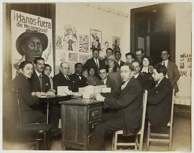 Group of men and women before a "Manos fuera de Nicaragua" poster