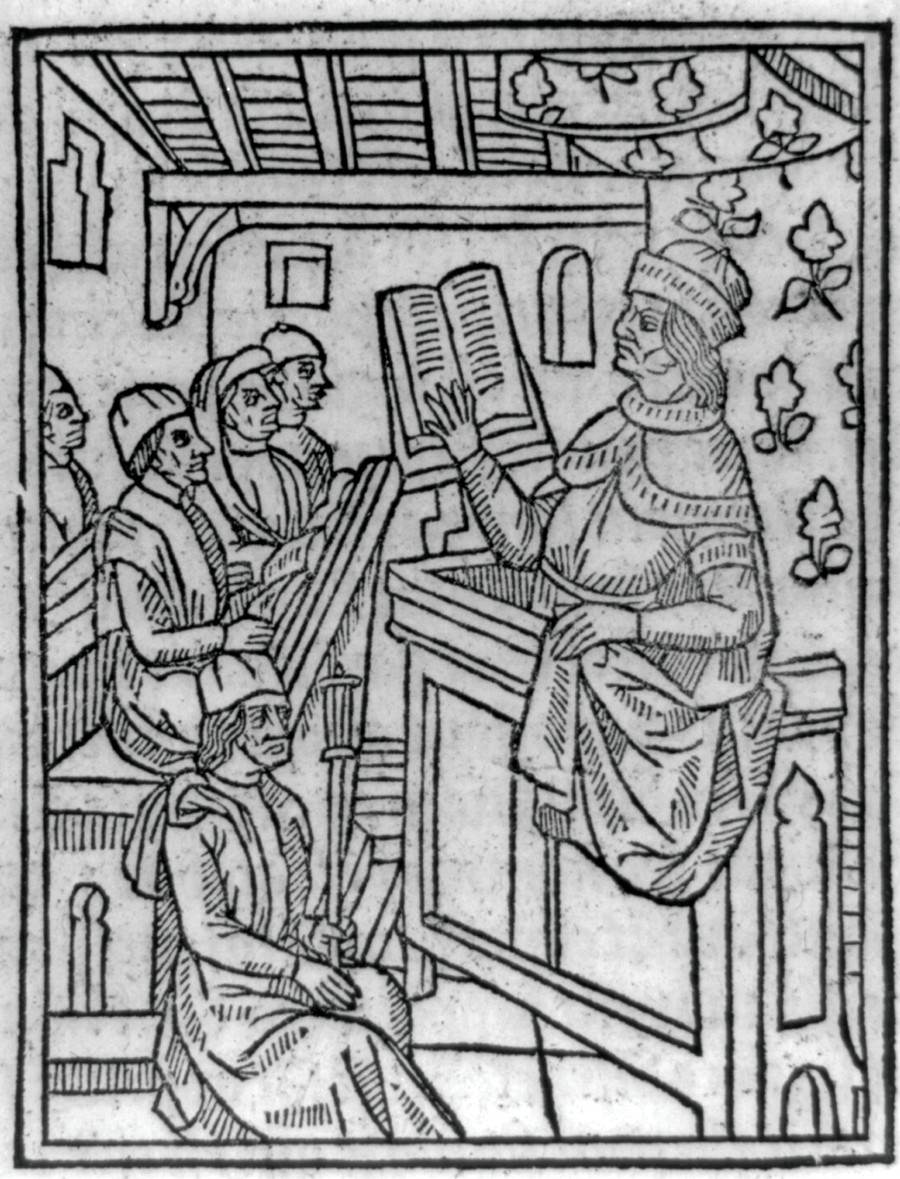 Teacher reading from open book at lectern, [no date recorded on caption card] — historic print