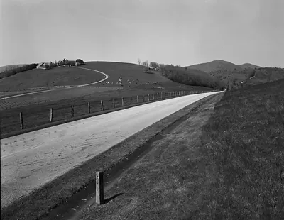 Blue Ridge Parkway curving road past farm and pasture