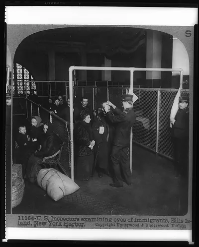 U.S. inspectors examining eyes of immigrants, Ellis Island, New York Harbor