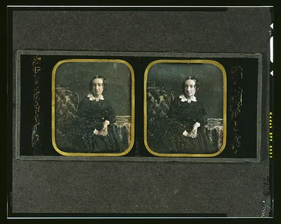 [Agnes Y. McAllister, three-quarters length, seated in ornate chair, with arm resting on table with tablecloth]