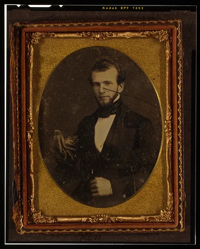 [Unidentified man, half-length portrait, facing left, seated in chair]