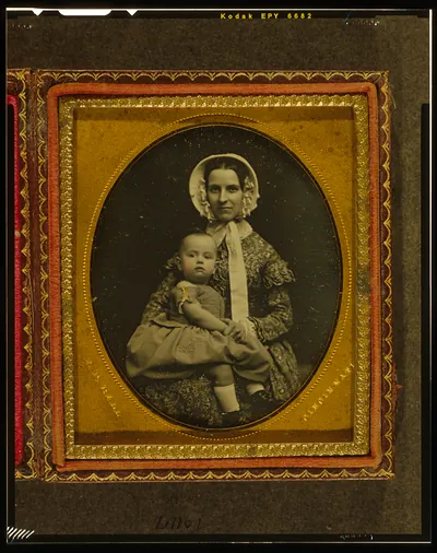 [Unidentified woman holding child in her lap]