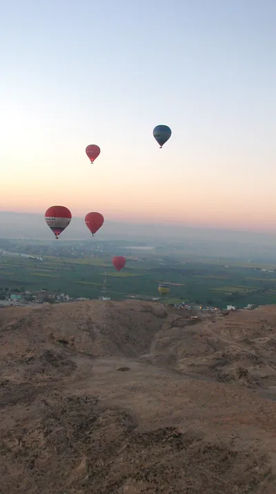 Hot air balloons over a valley at dawn