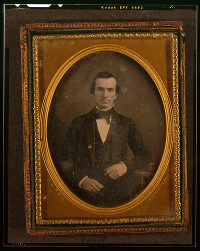 [Unidentified man, half-length portrait, with arm resting on table with tablecloth]