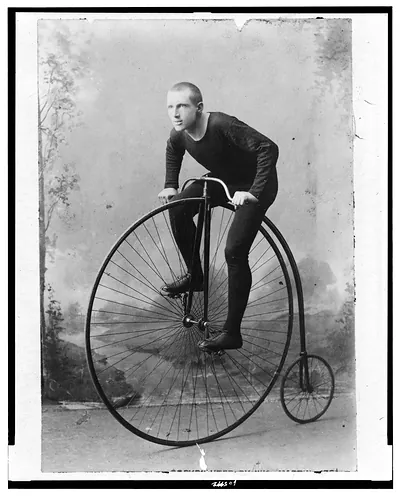 [William Martin, champion six-day bicycle rider of the world, full-length portrait, facing left, on bicycle with large front wheel and small rear wheel]