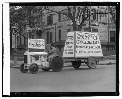 Fordson tractor pulling Ford Commercial Cars advertising trailer