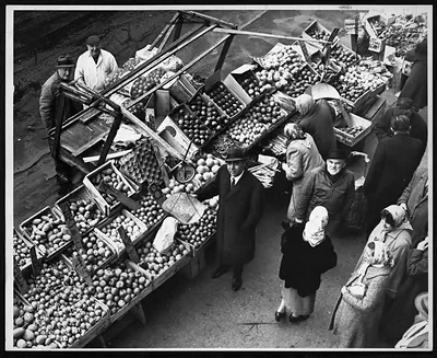Overhead view of fruit stall with shoppers, black and white photograph