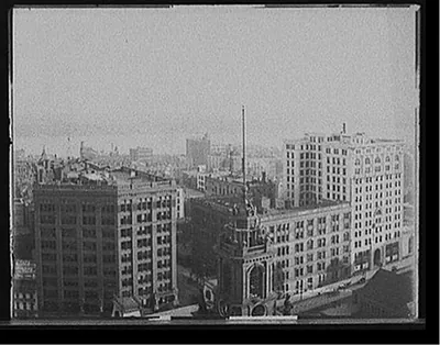 [Church tower, commercial buildings and waterfront, probably Detroit]