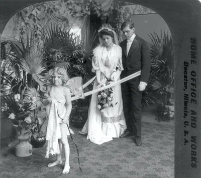 Bride and groom with Cupid in a staged studio setting