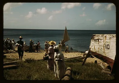 Fishermen and women on a Caribbean beach with boats