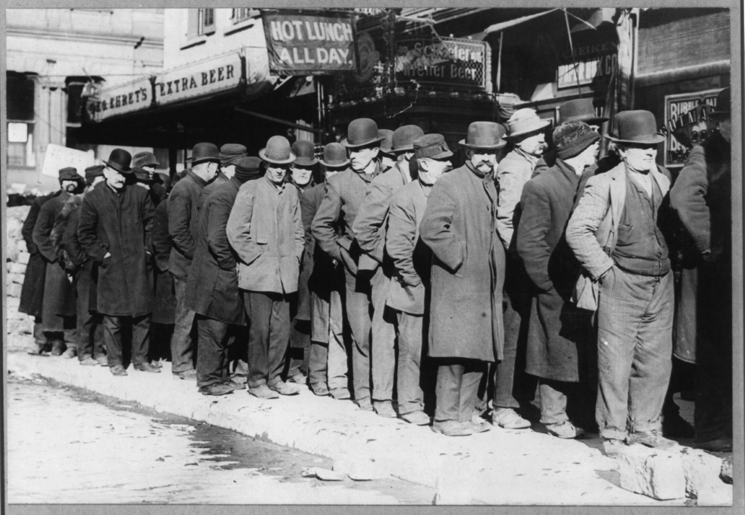 Bowery men waiting for bread in bread line, [New York City], 1910 Feb. 7. — historic photograph