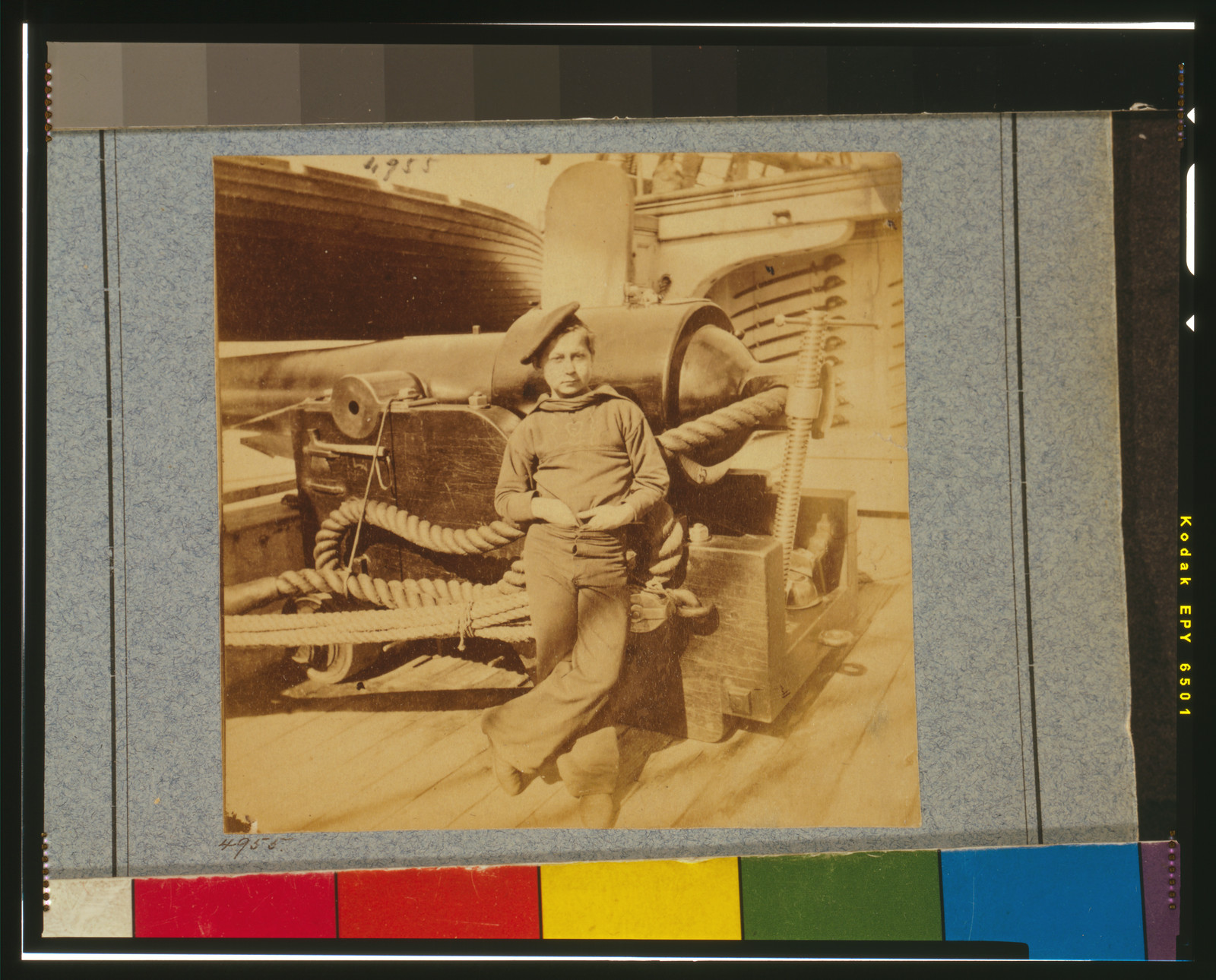 Sailor leaning against a cannon on a warship deck — historic image