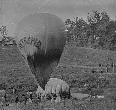 Observation balloon being inflated among soldiers on a hillside
