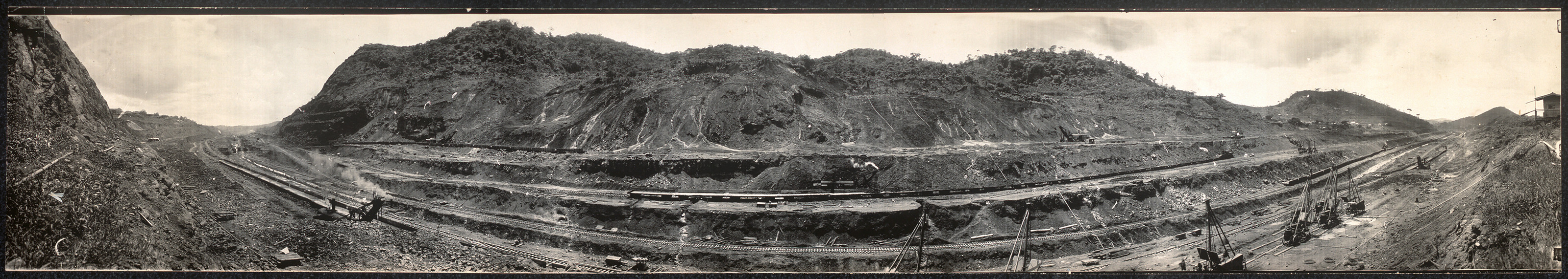 Panoramic photograph of Panama Canal excavation cut with railway tracks — historic photograph