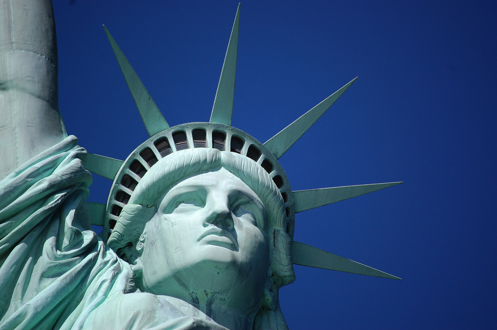 Statue of Liberty face and crown against blue sky — historic image