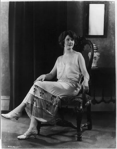[Woman modeling clothing: Satin of shell pink colour is trimmed with crystal fringe...make up this gown, which is also enhanced by amethist drops; It is sponsored by Maurice Mendel]