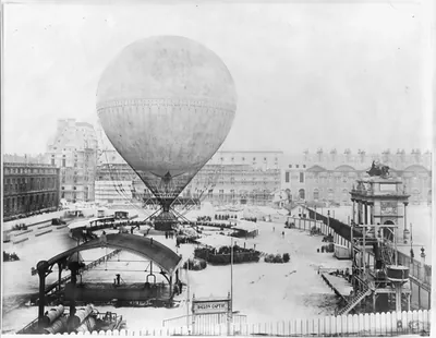 [Grand Balloon... de Mr. Henry Giffard, 1878 - Birds-eye view of Balloon before ascent from Tuillerie Gardens, Paris; large crowd and reviewing stands]