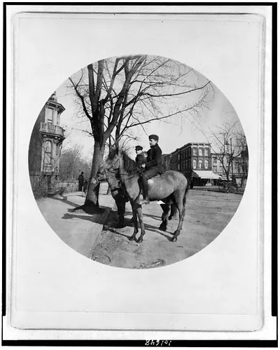 [Two boys on horses at corner of 14th St. and I St. N.W., Washington, D.C. View looking east on I St., Franklin Square on left, stores on 14th St. on right]
