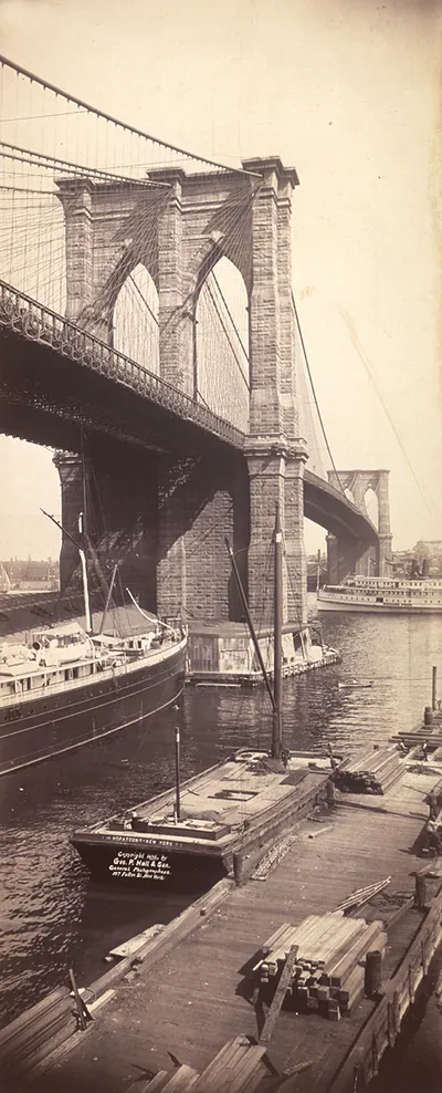 Brooklyn Bridge tower above moored ships and timber barges