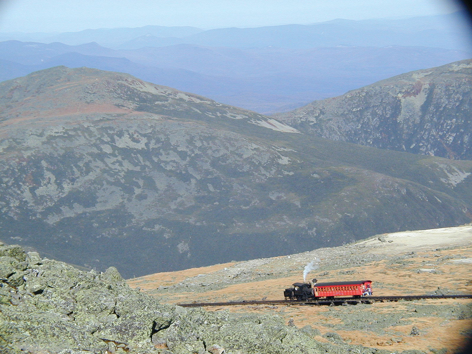 Red cog railway train climbing a barren mountainside — historic image