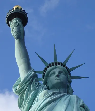Statue of Liberty torch and crown against blue sky